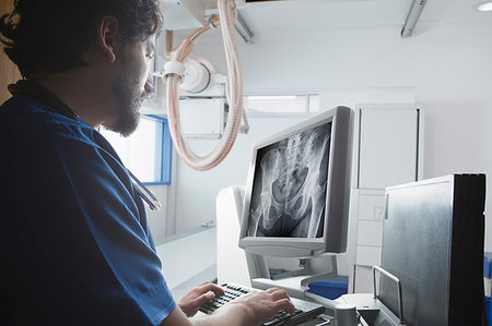 simsearch:614-06813654,k - Young male radiographer looking at Xray of pelvis in radiology department Foto de stock - Sin royalties Premium, Código: 614-09276977
