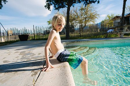 Boy sitting by swimming pool, Olancha, California, US Stock Photo - Premium Royalty-Free, Code: 614-09270504