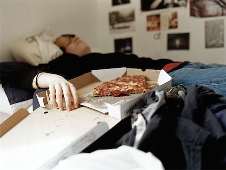 Boy sleeping with pizza on bed Stock Photo - Premium Royalty-Free, Code: 614-00653377