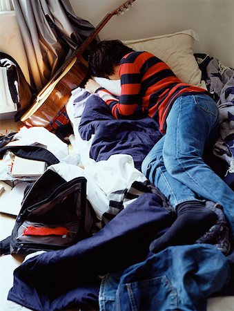 Boy sleeping on messy bed Stock Photo - Premium Royalty-Free, Code: 614-00653471