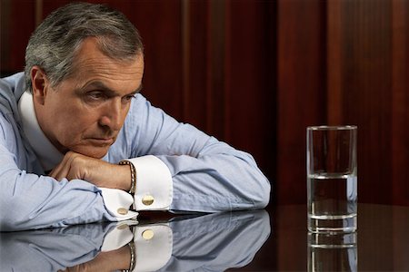 simsearch:649-07119200,k - Businessman looking pessimistically at a glass of water Stock Photo - Premium Royalty-Free, Code: 614-00891742