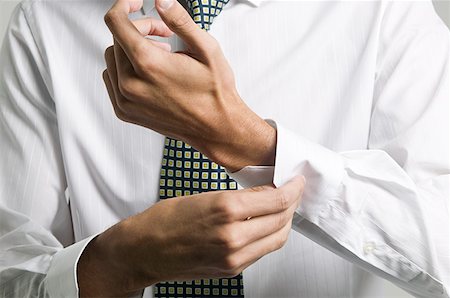 Man buttoning cuff of his shirt Stock Photo - Premium Royalty-Free, Code: 614-01088244