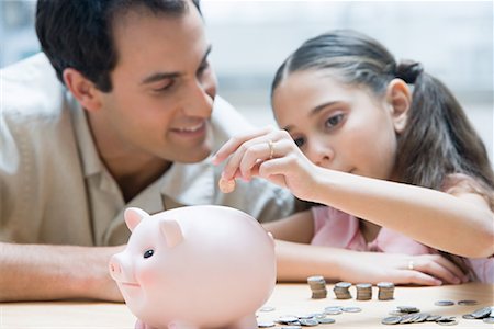 Father and daughter with piggy bank Stock Photo - Premium Royalty-Free, Code: 614-01178499