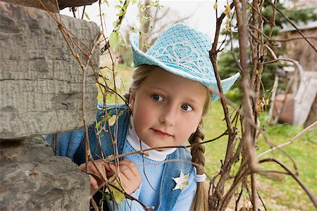 Cowgirl peering round corner Stock Photo - Premium Royalty-Free, Code: 614-01237599