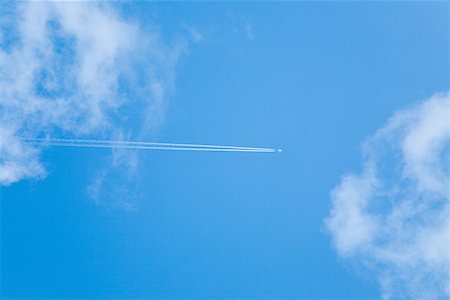 Aeroplane and vapour trail in sky Stock Photo - Premium Royalty-Free, Code: 614-01268625