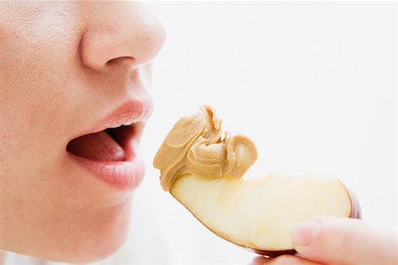 Woman eating apple and peanut butter Stock Photo - Premium Royalty-Free, Code: 614-01560867