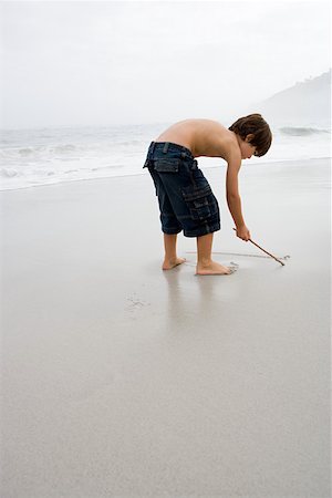 Boy drawing in the sand Stock Photo - Premium Royalty-Free, Code: 614-01624531