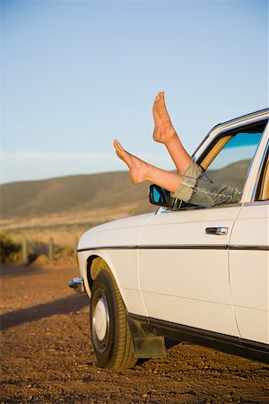 Young womans feet sticking out of a car window Stock Photo - Premium Royalty-Free, Code: 614-02049794