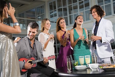 Man playing a ukelele at party Stock Photo - Premium Royalty-Free, Code: 614-02244068