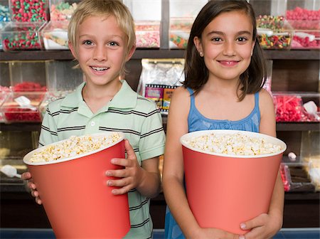 Two children holding tubs of popcorn Stock Photo - Premium Royalty-Free, Code: 614-02393035