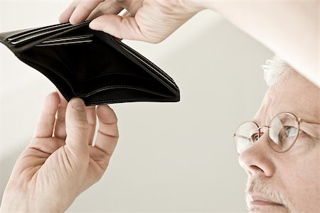 A man looking in an empty wallet Stock Photo - Premium Royalty-Free, Code: 614-02393222