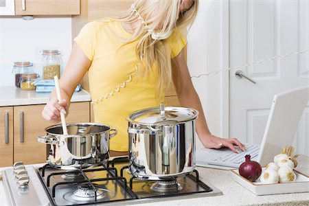 phone cord - Woman cooking whilst on telephone and using laptop Stock Photo - Premium Royalty-Free, Code: 614-02613129