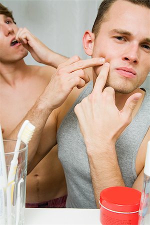 pimple - A man squeezing a spot in the mirror Stock Photo - Premium Royalty-Free, Code: 614-02613472