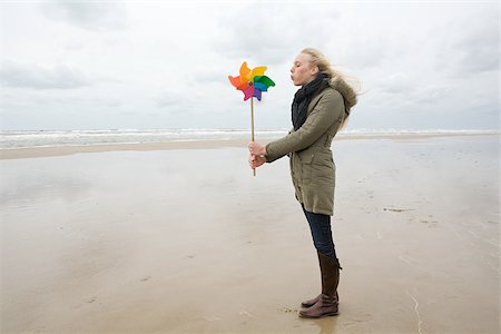 Young woman by sea with pinwheel Stock Photo - Premium Royalty-Free, Code: 614-02639991