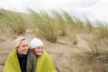 Women sharing a blanket on dune Stock Photo - Premium Royalty-Free, Code: 614-02640007