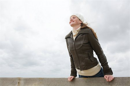 Woman leaning over wall Stock Photo - Premium Royalty-Free, Code: 614-02640048
