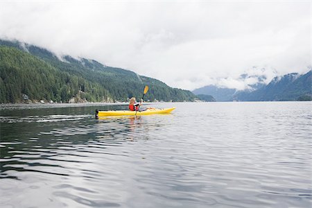 Woman kayaking in fjord Stock Photo - Premium Royalty-Free, Code: 614-02679054