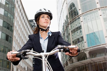 Woman cycling in city Stock Photo - Premium Royalty-Free, Code: 614-02679423