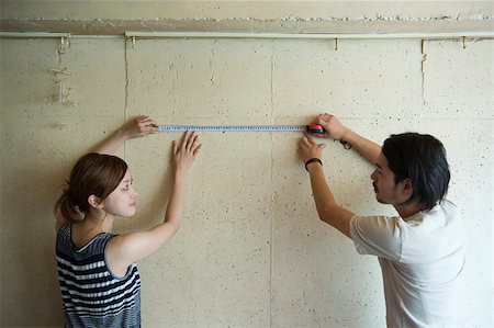 Young couple measuring wall Stock Photo - Premium Royalty-Free, Code: 614-02681084