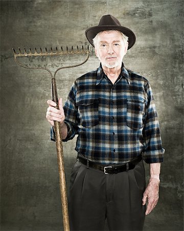 Portrait of a farmer holding a rake Stock Photo - Premium Royalty-Free, Code: 614-02763922