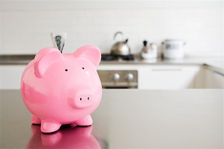 piggy bank - Piggy bank with money in slot Stock Photo - Premium Royalty-Free, Code: 614-02934140