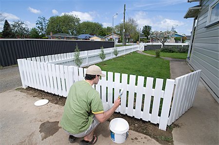 pictures of house with picket fence - Man painting fence Stock Photo - Premium Royalty-Free, Code: 614-02934359