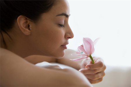 Young woman holding an orchid flower Stock Photo - Premium Royalty-Free, Code: 614-03020093