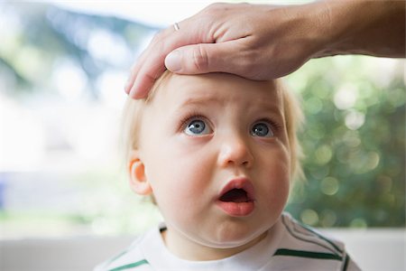 Adult hand on head of baby Stock Photo - Premium Royalty-Free, Code: 614-03020240