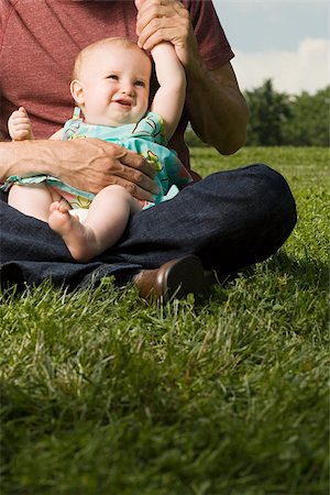 daughter sitting on dad lap - Father with baby girl on lap Stock Photo - Premium Royalty-Free, Code: 614-03080105