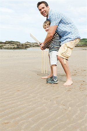 Father and son playing cricket on beach Stock Photo - Premium Royalty-Free, Code: 614-03080525