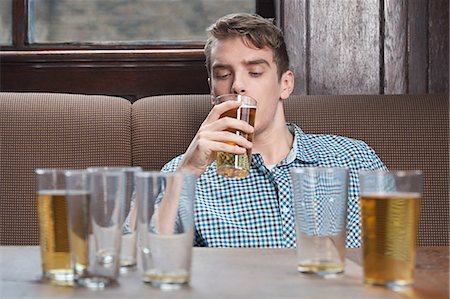 Young man drinking beer in bar Foto de stock - Sin royalties Premium, Código: 614-03393383