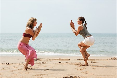 Two women practicing yoga on a beach Stock Photo - Premium Royalty-Free, Code: 614-03420375