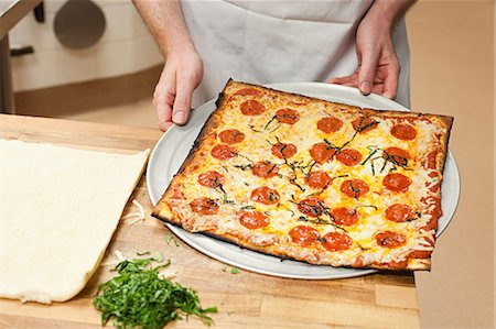 Male chef making pizza in commercial kitchen Stock Photo - Premium Royalty-Free, Code: 614-03551551