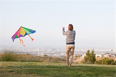 sky in kite alone pic - Young man flying a kite Foto de stock - Sin royalties Premium, Código: 614-03551703