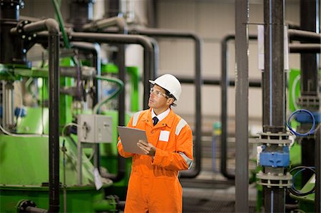 Engineer inspecting machinery in factory Stock Photo - Premium Royalty-Free, Code: 614-03552231