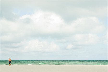 people walking in the distance - Man on beach by the sea Stock Photo - Premium Royalty-Free, Code: 614-03576319