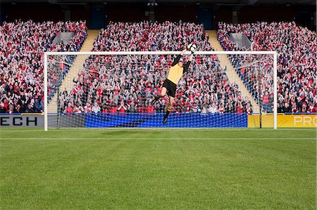 soccer game in stadium - Goalkeeper saving a goal Stock Photo - Premium Royalty-Free, Code: 614-03647741