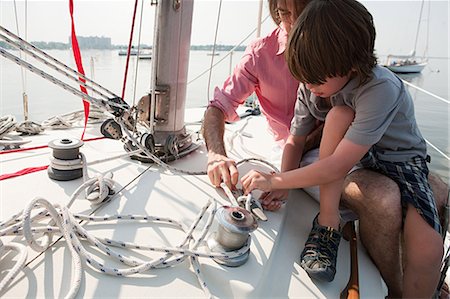 Father and son on board yacht with rope Stock Photo - Premium Royalty-Free, Code: 614-03647965