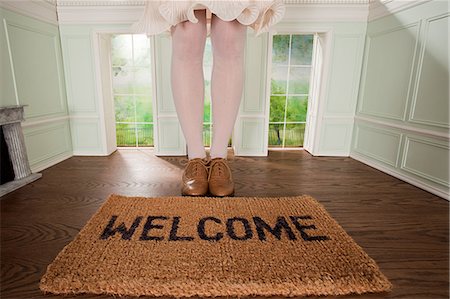 Legs of a woman and welcome mat in small room Stock Photo - Premium Royalty-Free, Code: 614-03684563