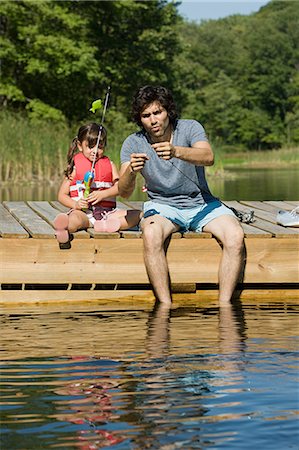 Father and daughter fishing from jetty Stock Photo - Premium Royalty-Free, Code: 614-03697051