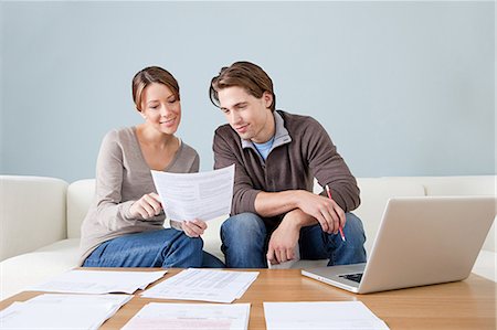 Young couple using computer and doing paperwork Stock Photo - Premium Royalty-Free, Code: 614-03697160