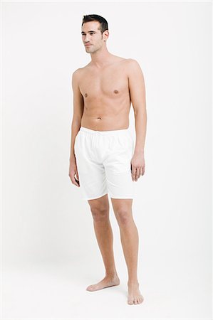 Portrait of young man wearing white boxer shorts Stock Photo - Premium Royalty-Free, Code: 614-03763536