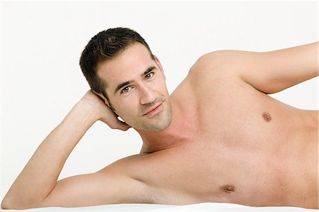 Portrait of young man resting on elbow Stock Photo - Premium Royalty-Free, Code: 614-03763608