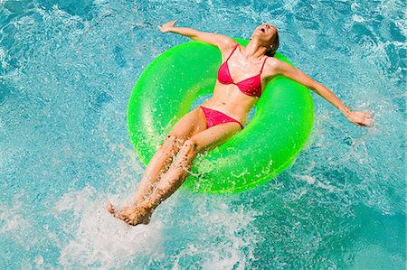 female inflatable ring - Young woman floating on green inflatable ring in swimming pool Stock Photo - Premium Royalty-Free, Code: 614-03763670