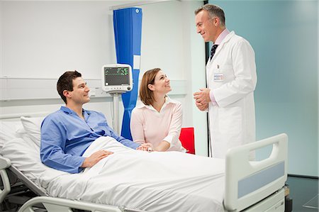 Wife visiting husband in hospital, talking to doctor Stock Photo - Premium Royalty-Free, Code: 614-03783670