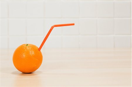 sticking out - Orange with drinking straw sticking out Stock Photo - Premium Royalty-Free, Code: 614-03903131