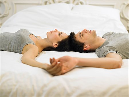 simsearch:614-06043612,k - Young couple lying on bed holding hands Stock Photo - Premium Royalty-Free, Code: 614-03981465