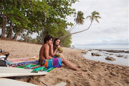 Young couple sitting on beach drinking coconut milk Stock Photo - Premium Royalty-Free, Code: 614-03981690