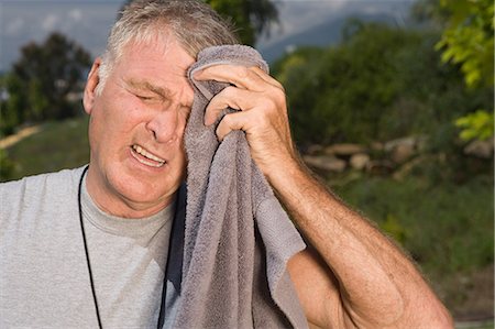 Senior man wiping face with towel after workout Stock Photo - Premium Royalty-Free, Code: 614-03981972