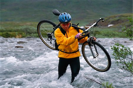 rapids - A woman carrying a bicycle in water. Stock Photo - Premium Royalty-Free, Code: 6102-03748068